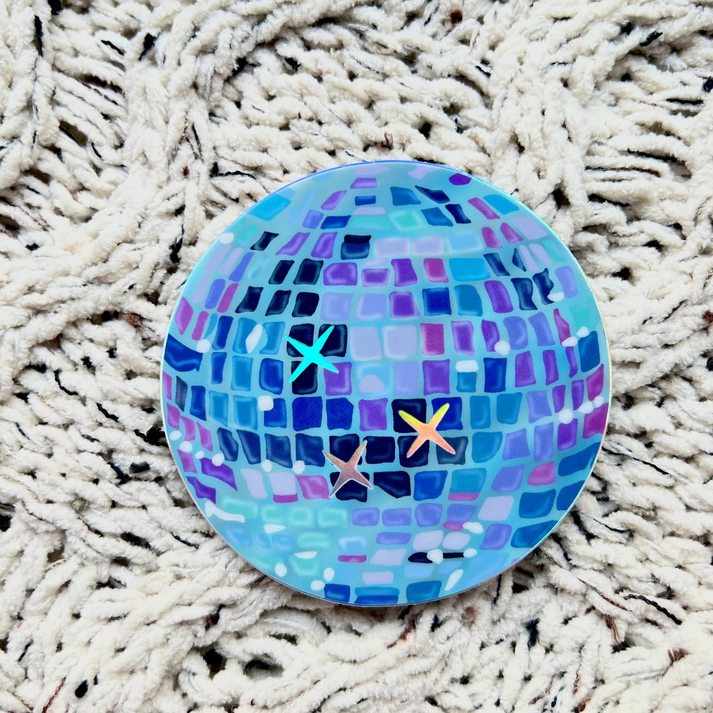 Blue disco ball sticker on a textured white surface