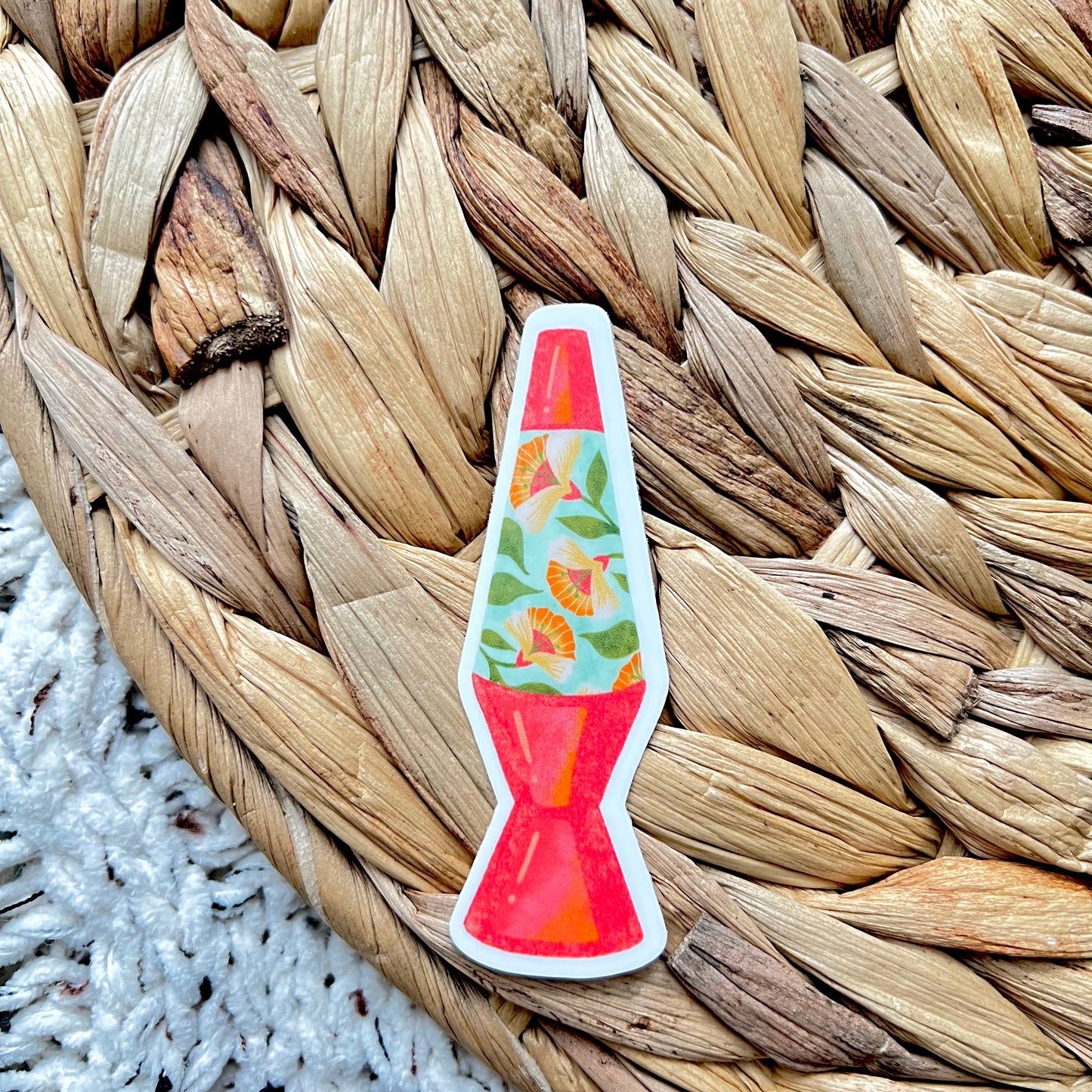 Sticker of a lava lamp with flowers inside on a woven mat