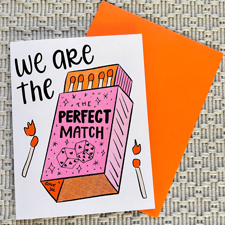 Greeting card with matchbox design and 'We are the perfect match' text on an orange envelope.