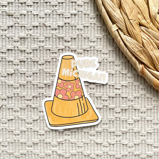 Sticker of a traffic cone with 'Pure Michigan' text on a textured surface
