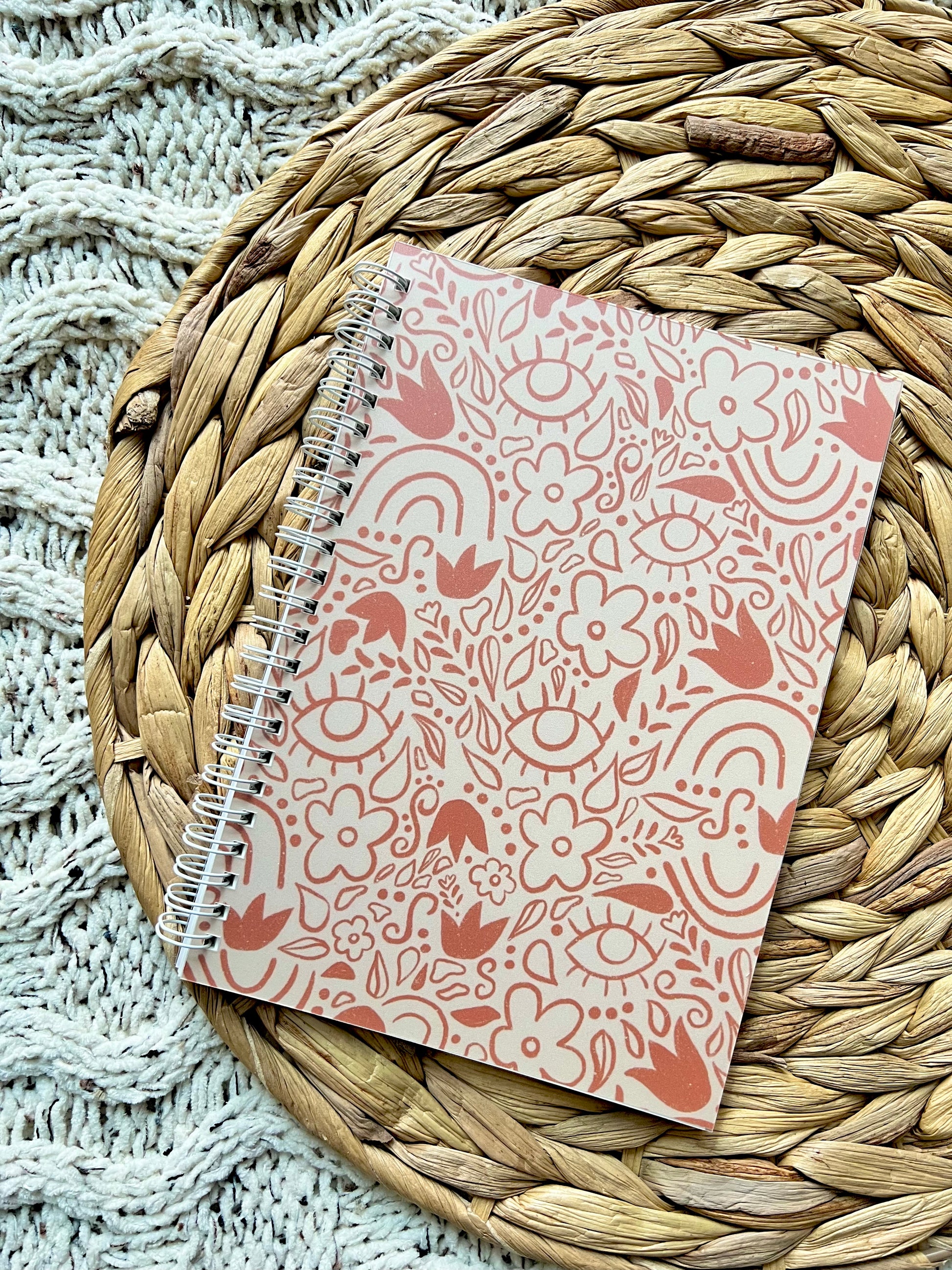 Notebook with floral pattern on a woven mat
