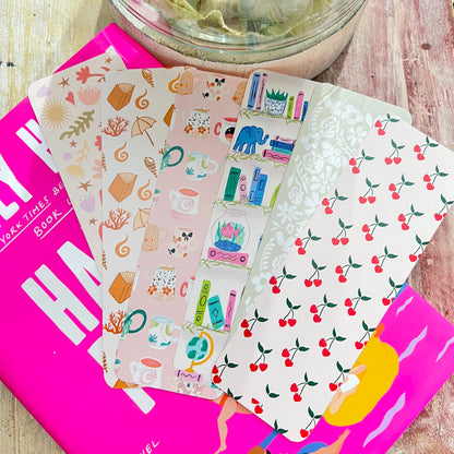 Bookmarks with various designs on a pink book