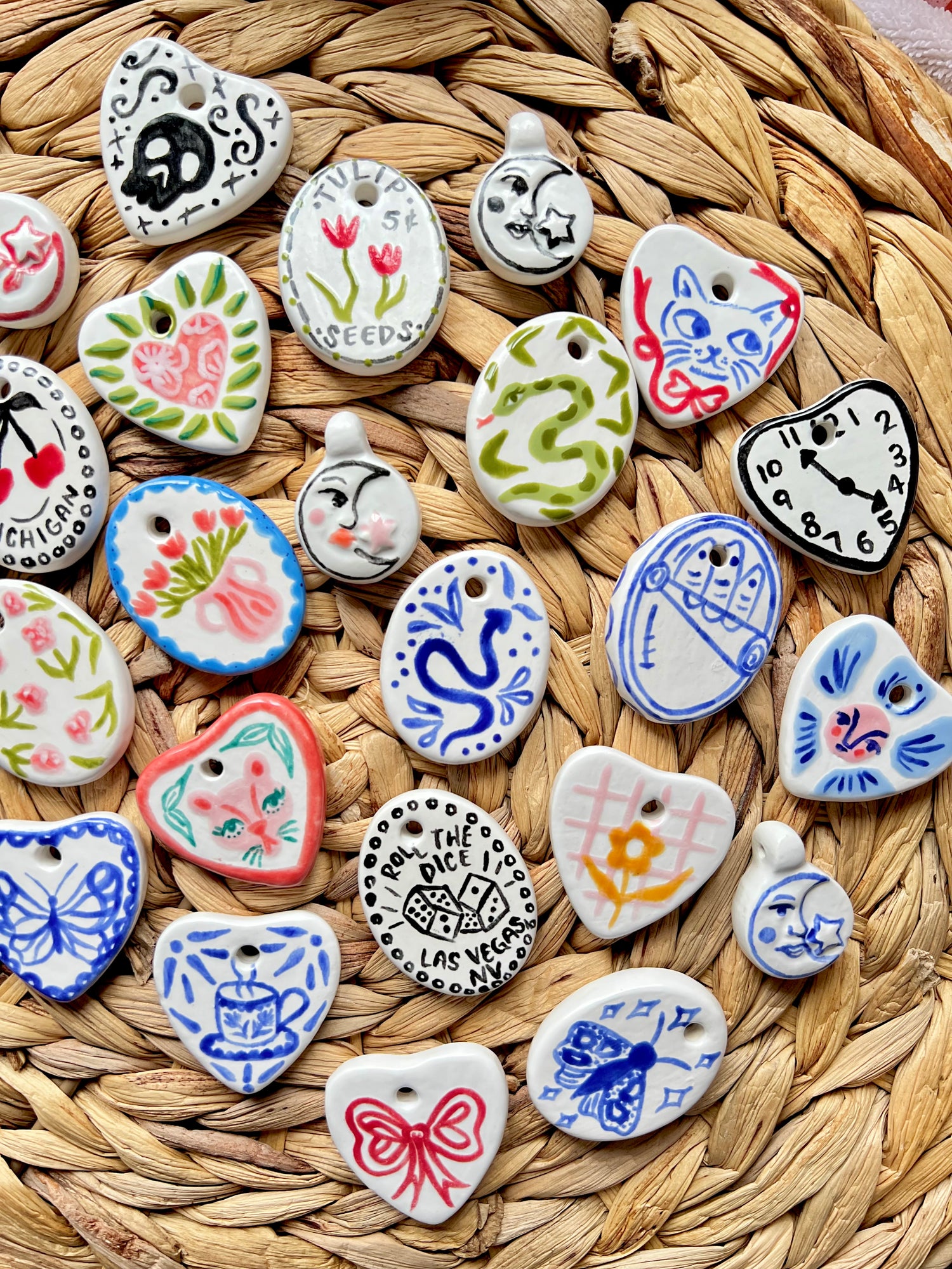 Collection of various ceramic charms on a woven surface