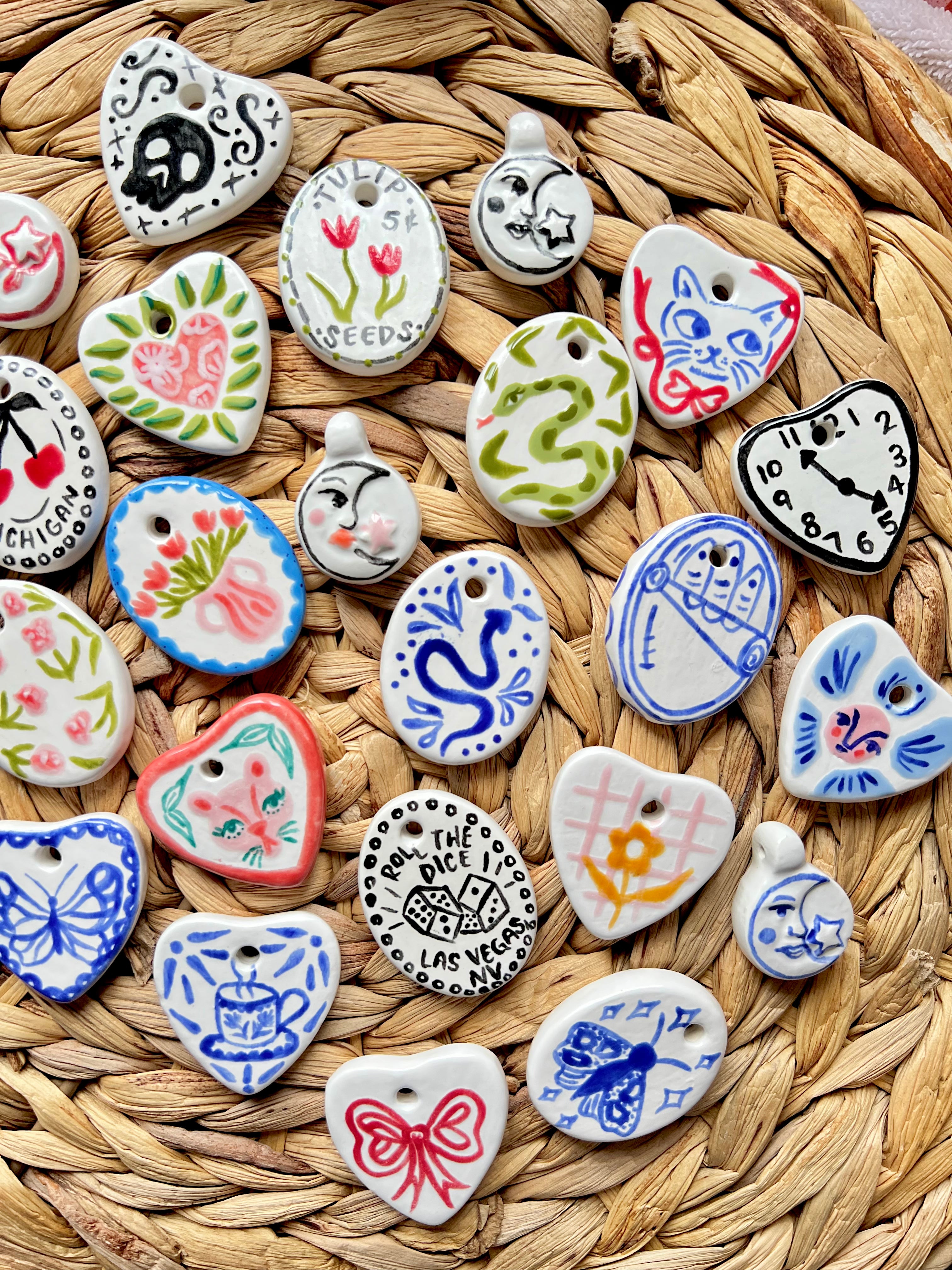 Collection of various ceramic charms on a woven surface