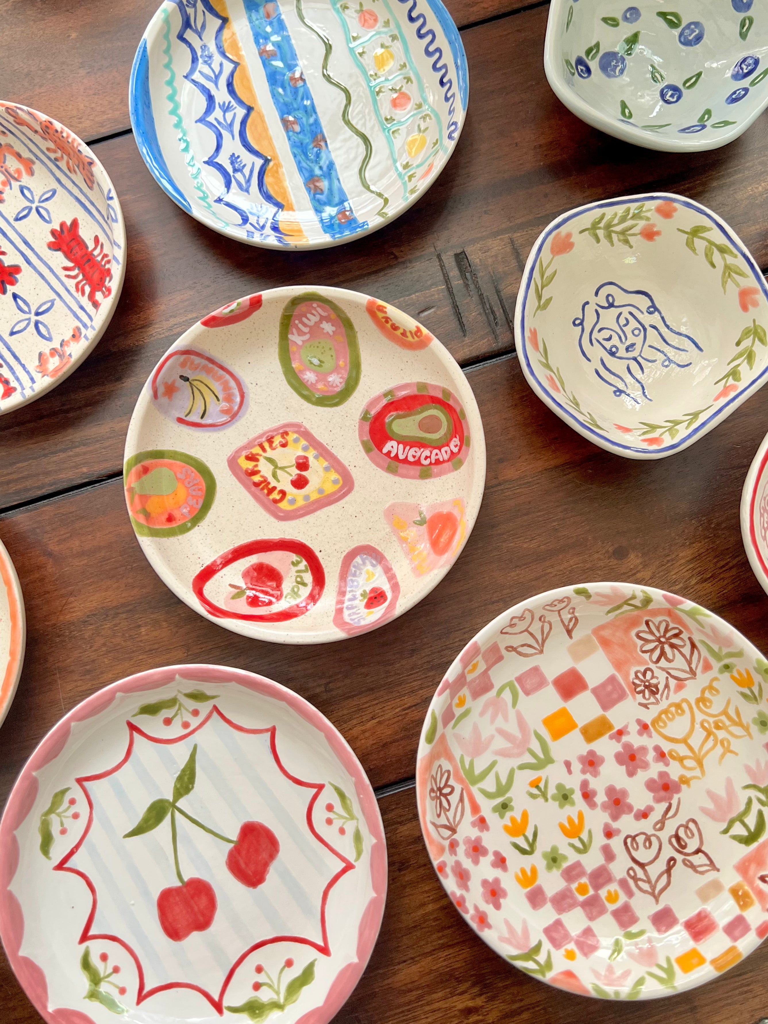 Collection of colorful ceramic plates with various patterns on a wooden surface