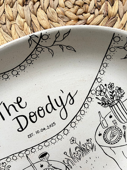 Ceramic tray with black decorative patterns and text on a woven surface