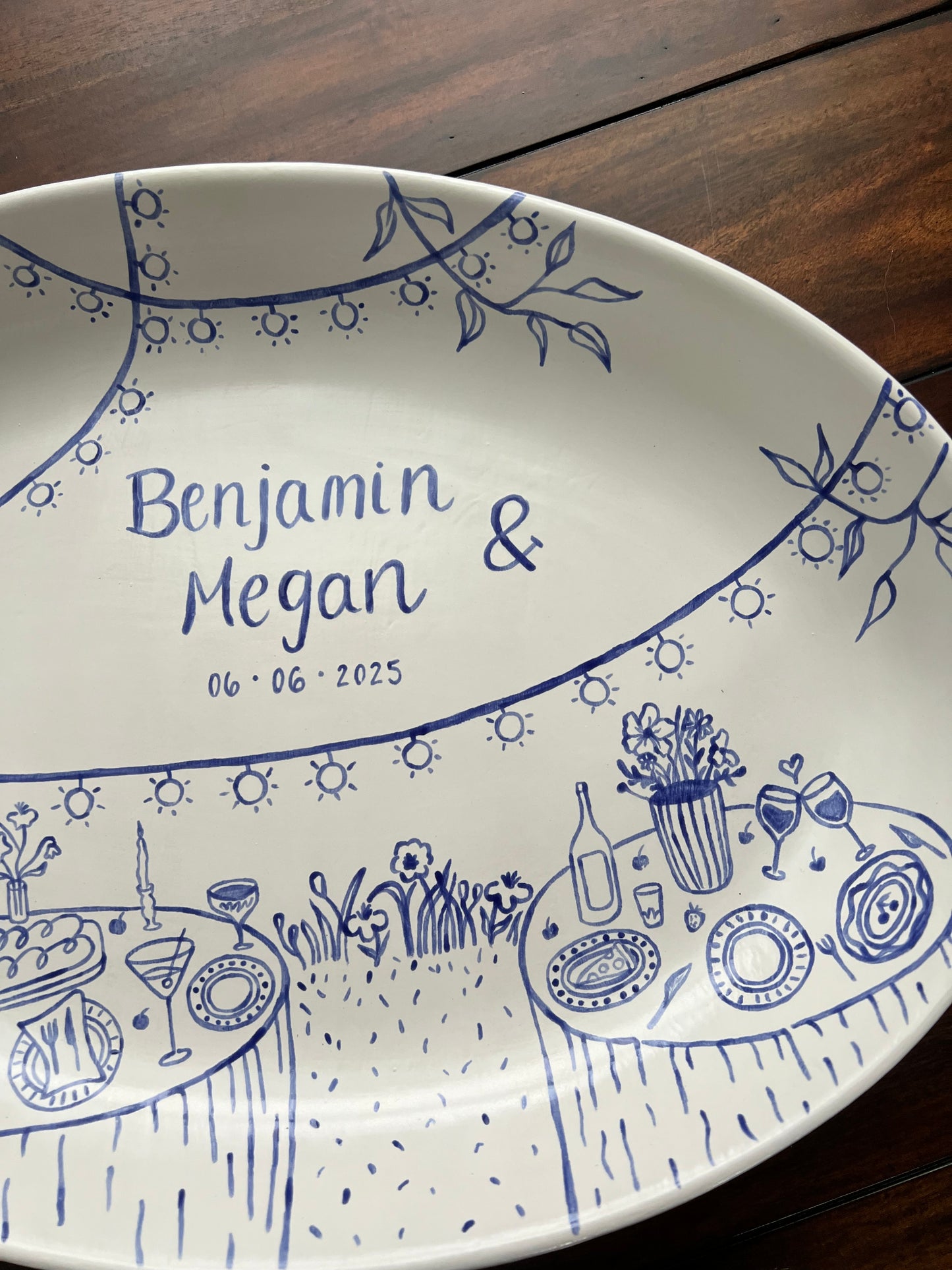 Decorative ceramic tray with blue designs and text on a wooden surface