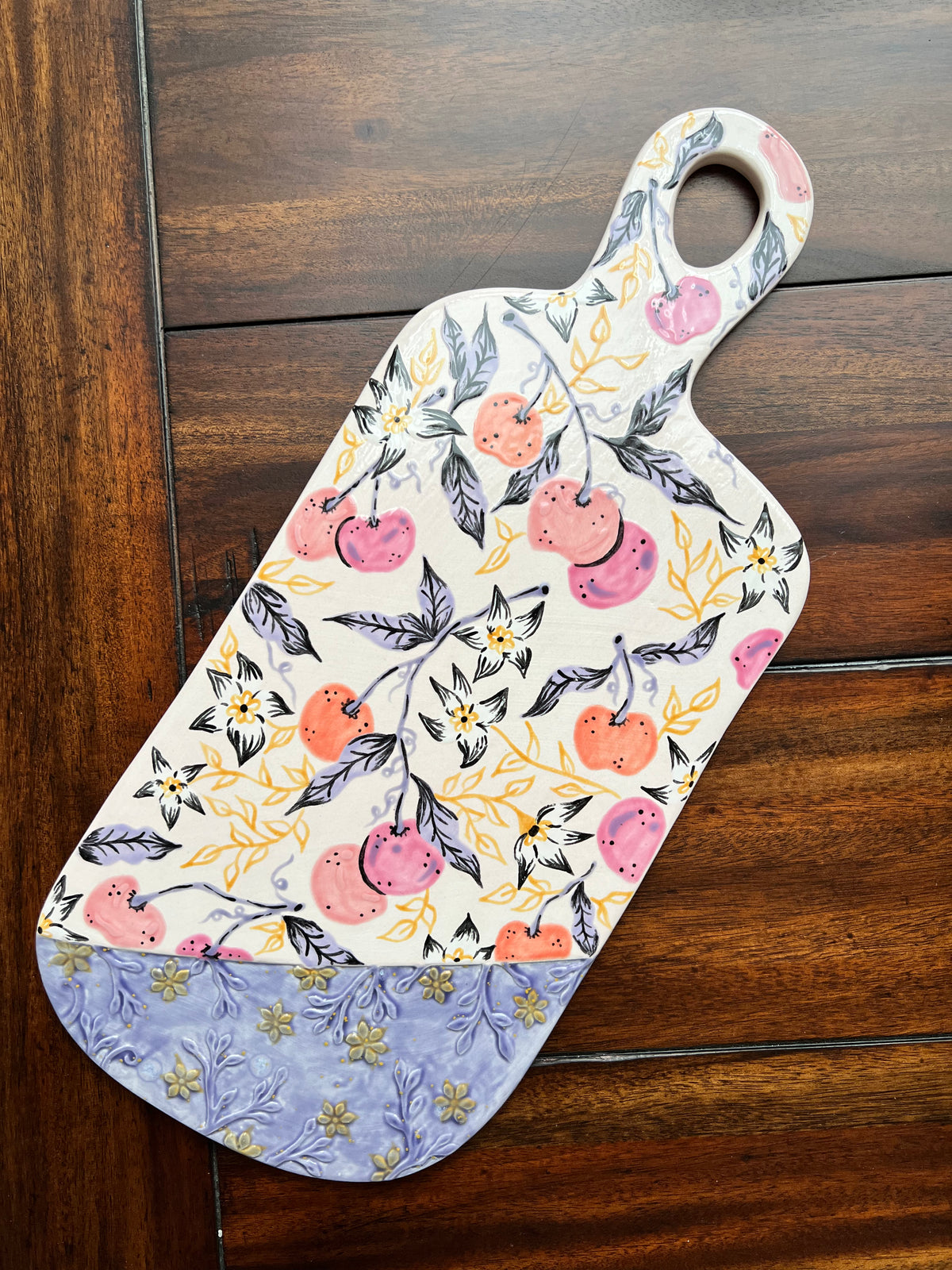 Decorative cutting board with floral pattern on a wooden surface