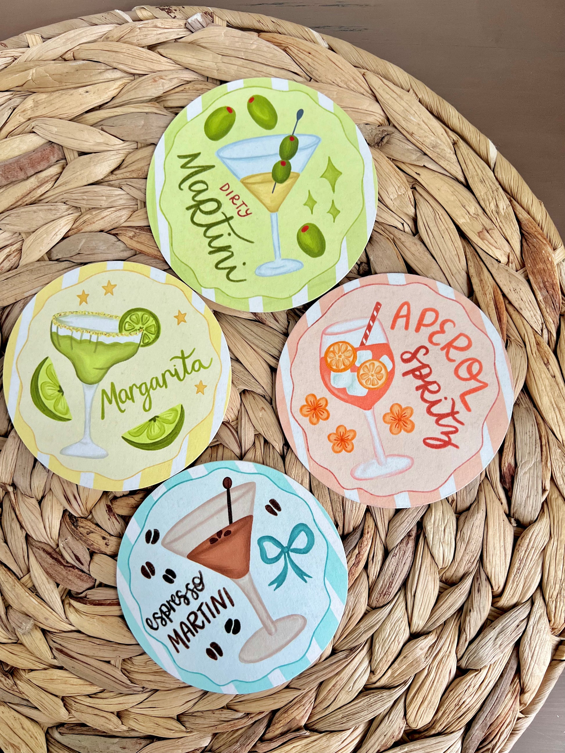 Set of four cocktail-themed coasters on a woven surface