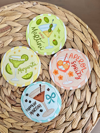 Set of four cocktail-themed coasters on a woven surface