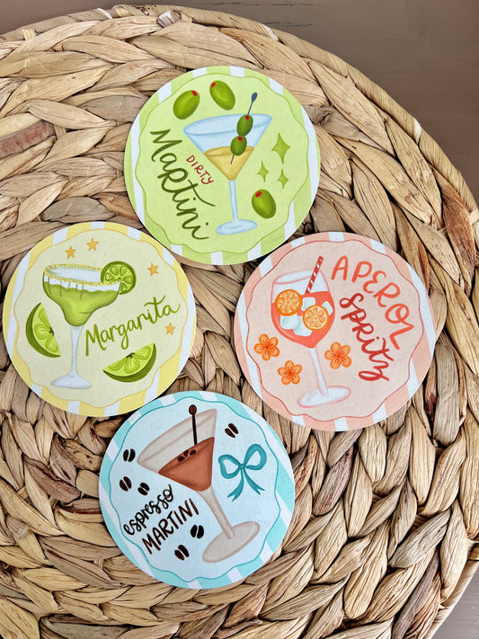 Set of four cocktail-themed coasters on a woven surface
