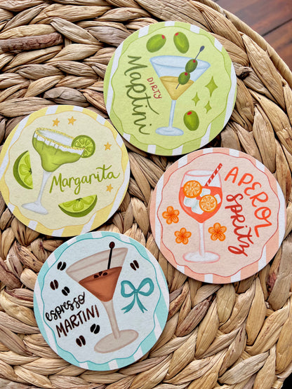 Set of four cocktail-themed coasters on a woven surface