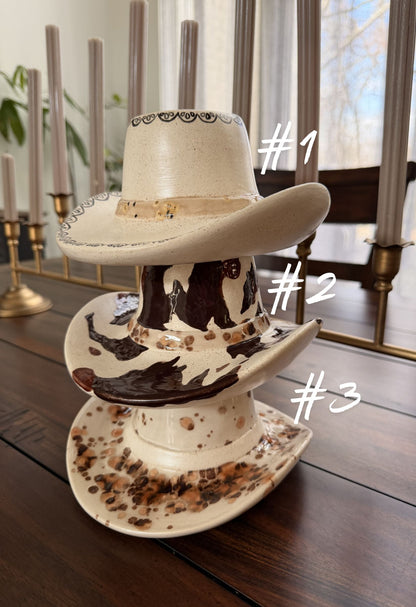 three ceramic cowboy hats stacked sitting on a wooden table 