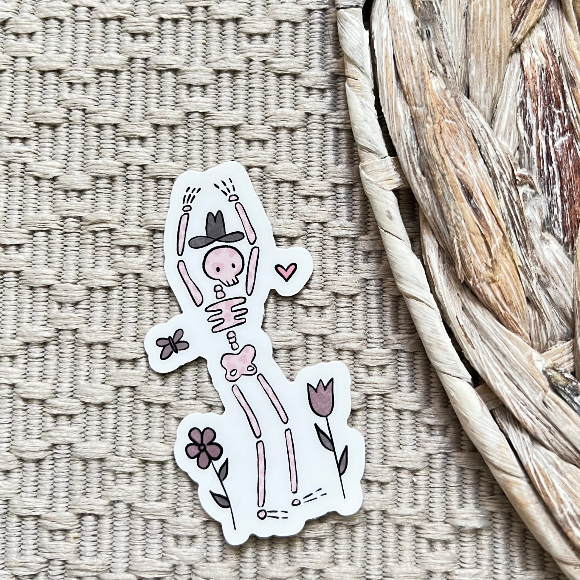 Sticker of a skeleton with flowers and a cowboy hat on a textured surface