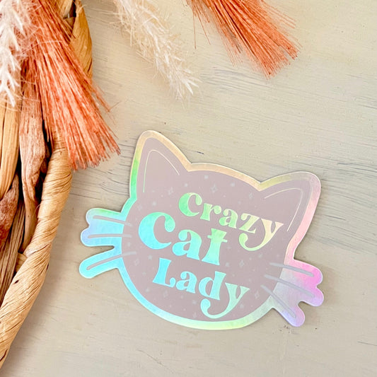 Holographic 'Crazy Cat Lady' sticker on a neutral background with decorative elements.