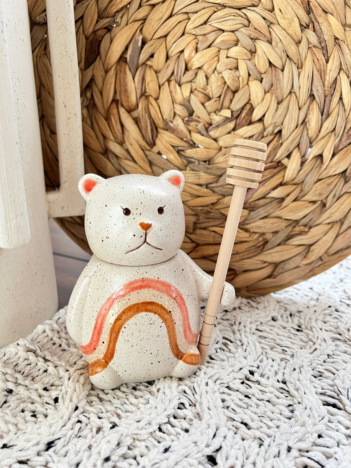 Ceramic bear figurine with honeycomb and dipper on a textured surface