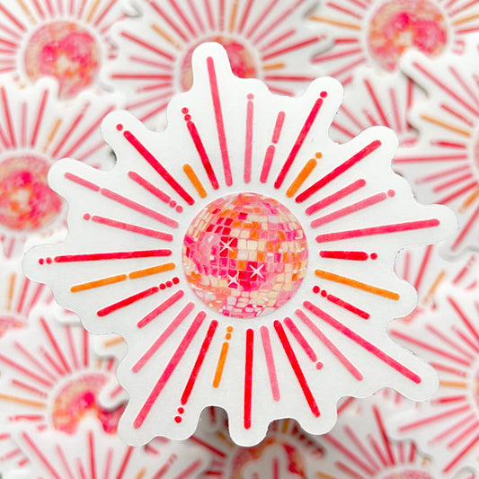 Sticker with a disco ball design on a pink and orange sunburst pattern