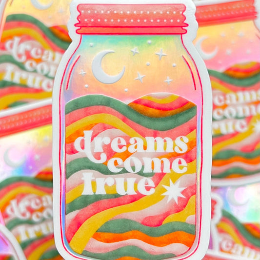 Holographic sticker with 'dreams come true' text written in a mason jar with a moon
