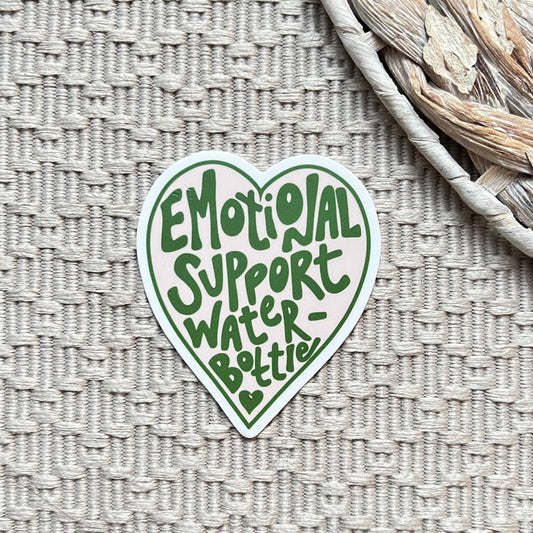 Heart-shaped sticker with 'Emotional Support Water Bottle' text on a textured surface