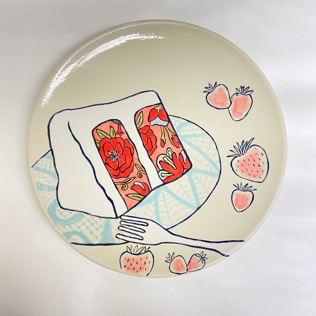 Ceramic plate with artistic design of cake and strawberries on a white background