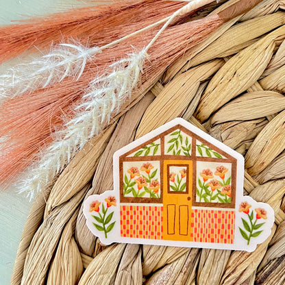 Decorative sticker of a small house with floral design on a woven mat background