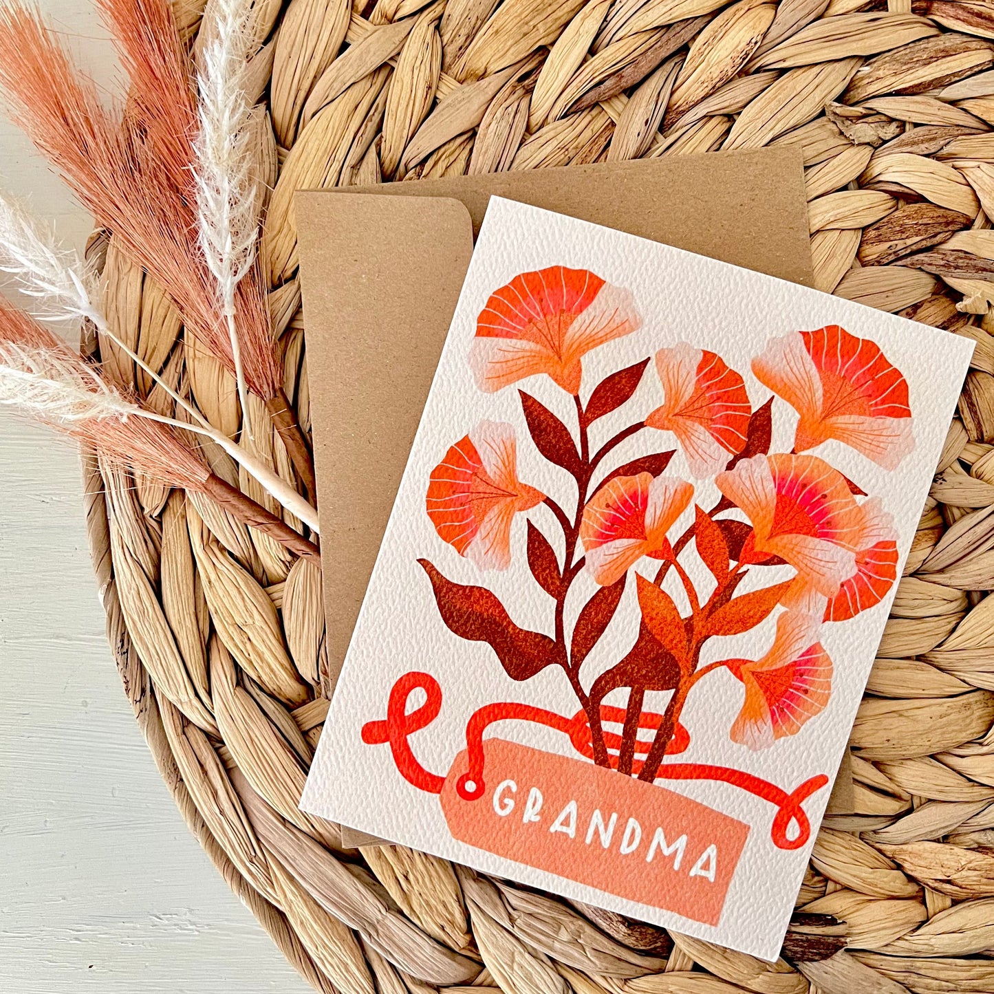 Greeting card with floral design and 'Grandma' text on a woven surface