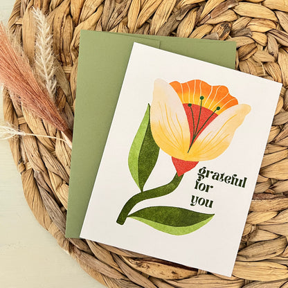 Greeting card with floral design and text saying "grateful for you" on a woven mat