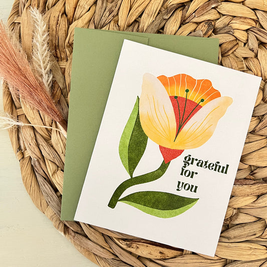 Greeting card with floral design and text saying "grateful for you" on a woven mat