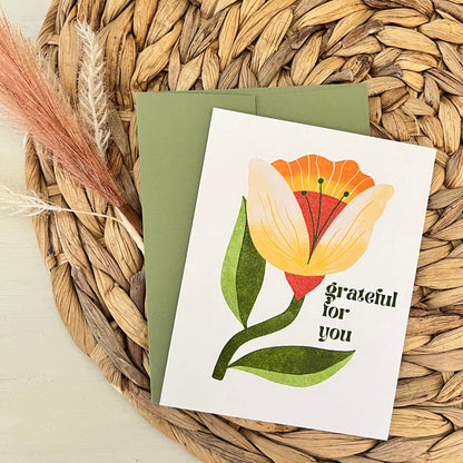 Greeting card with floral design and 'Grateful for you' text on a woven mat.