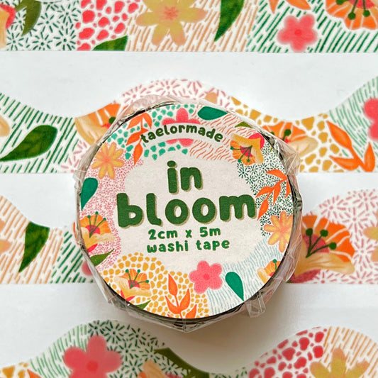 Roll of washi tape with floral design and 'in bloom' text on a matching patterned background.