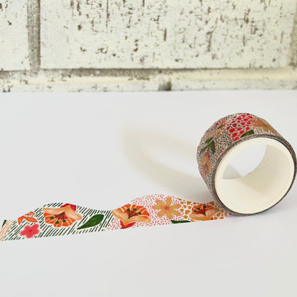 Roll of floral-patterned tape on a white surface with a brick wall background