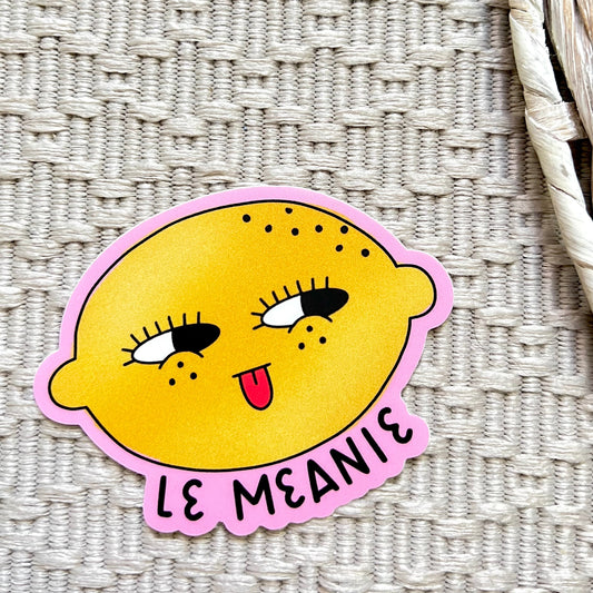 Sticker with a lemon character and 'Le Meanie' text on a textured surface