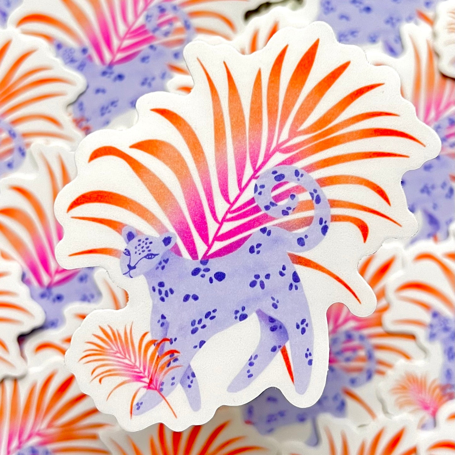 Sticker of a purple and white leopard with pink and orange leaf-like patterns on a matching patterned background.