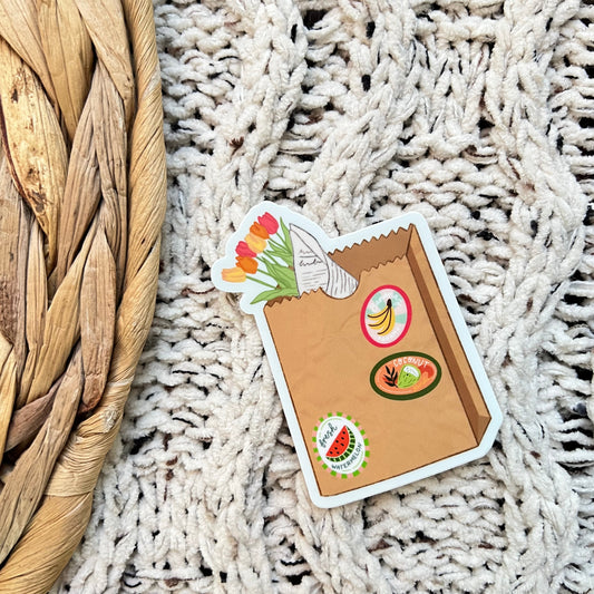 Sticker of a brown bag design featuring food icons on a textured surface