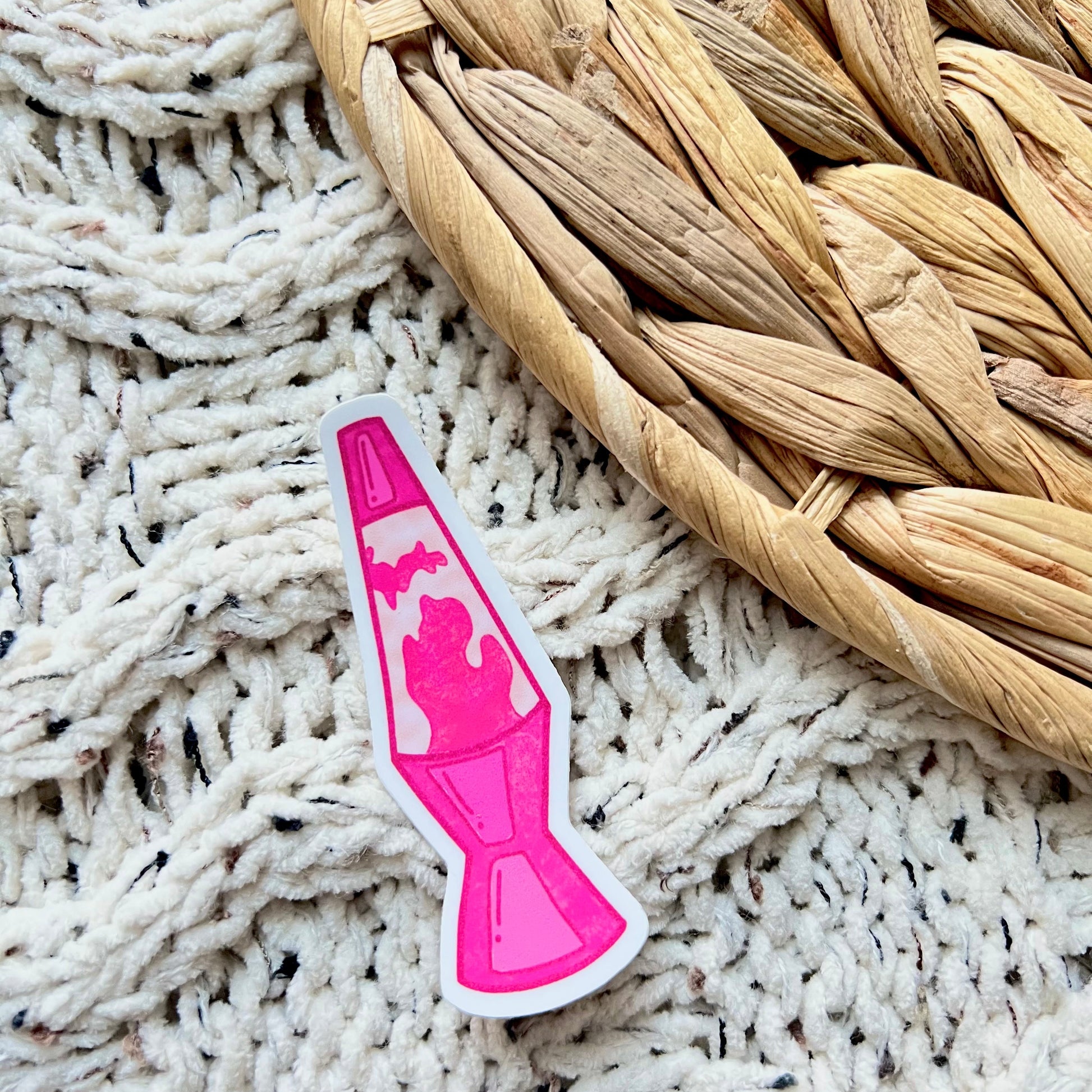 Pink lava lamp-shaped sticker on a textured surface