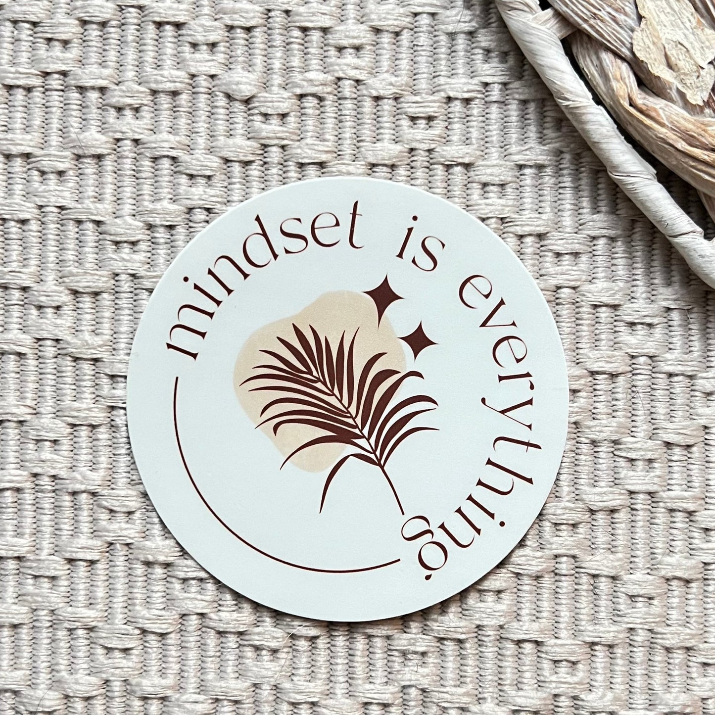Circular sticker with 'mindset is everything' text on a textured surface