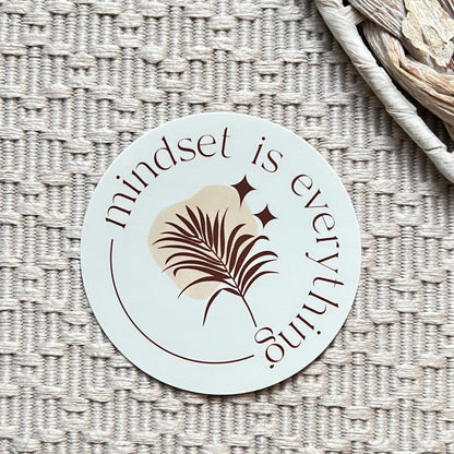 Circular sticker with 'mindset is everything' text on a textured surface