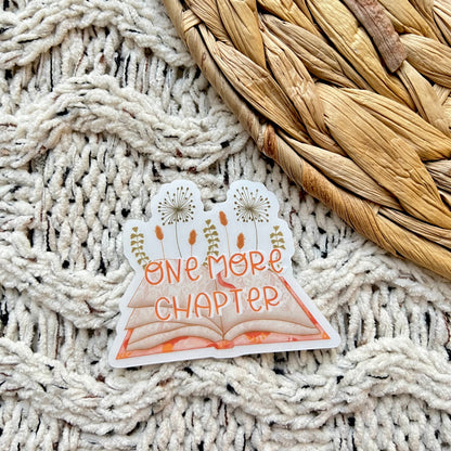 Sticker with 'One More Chapter' text on a textured surface