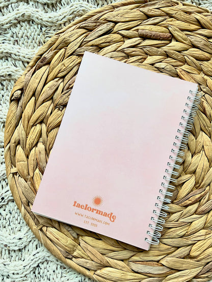 Beige notebook with spiral binding on a woven mat