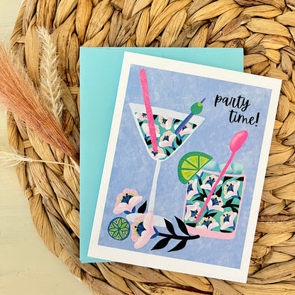 Greeting card with floral cocktail design and 'party time!' text on a woven mat