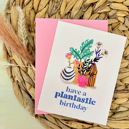 Greeting card with plant illustrations and text on a woven mat