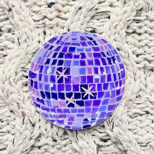 Purple disco ball illustration sticker with holographic stars on a woven blanket