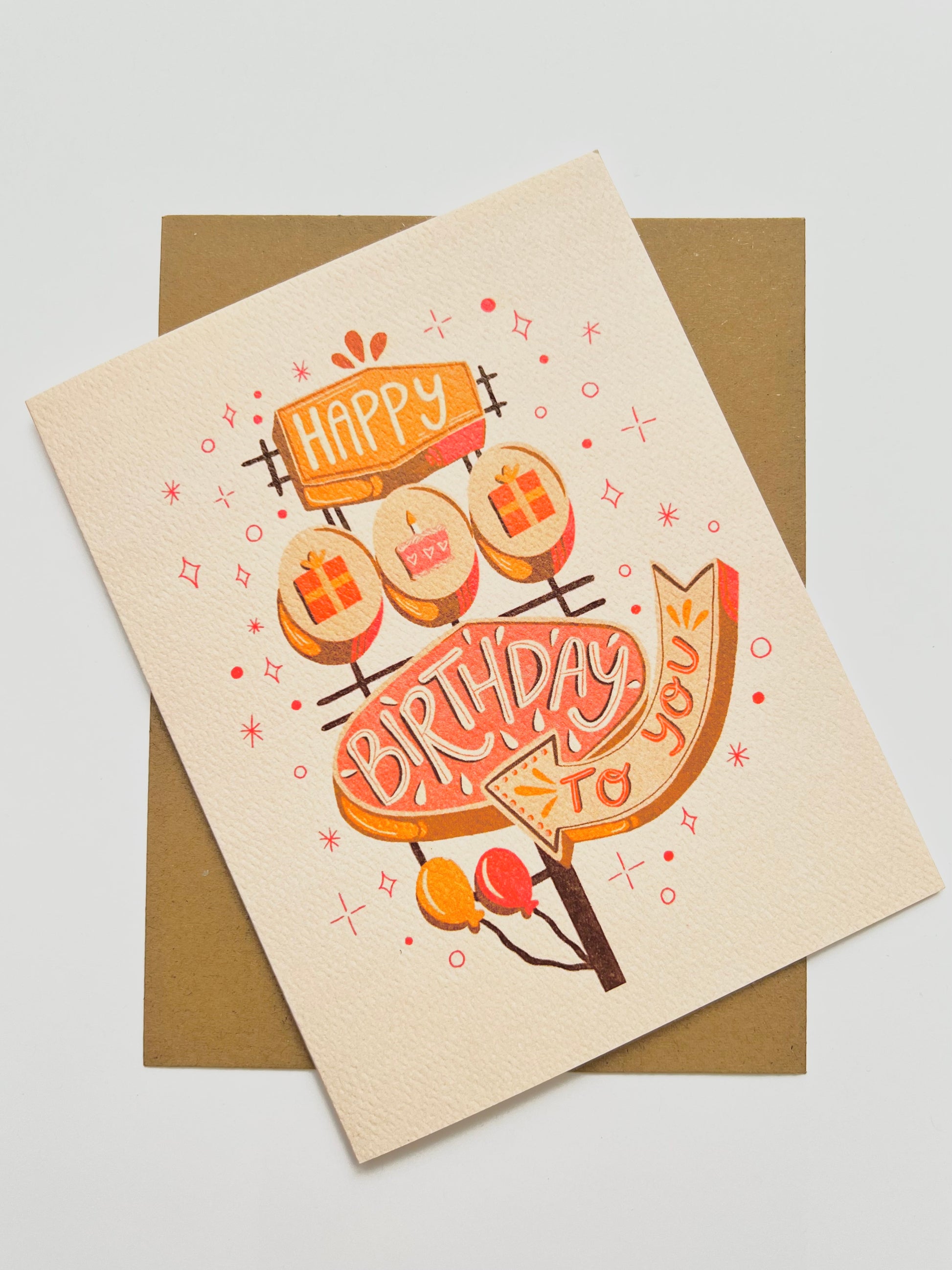 Birthday card with illustration of retro sign saying "happy birthday to you"  on a beige background
