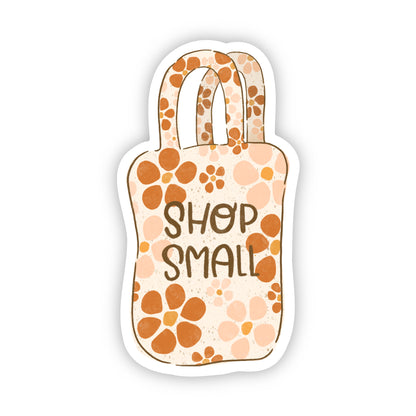 Sticker of a tote bag with 'Shop Small' text and a floral pattern on a white background