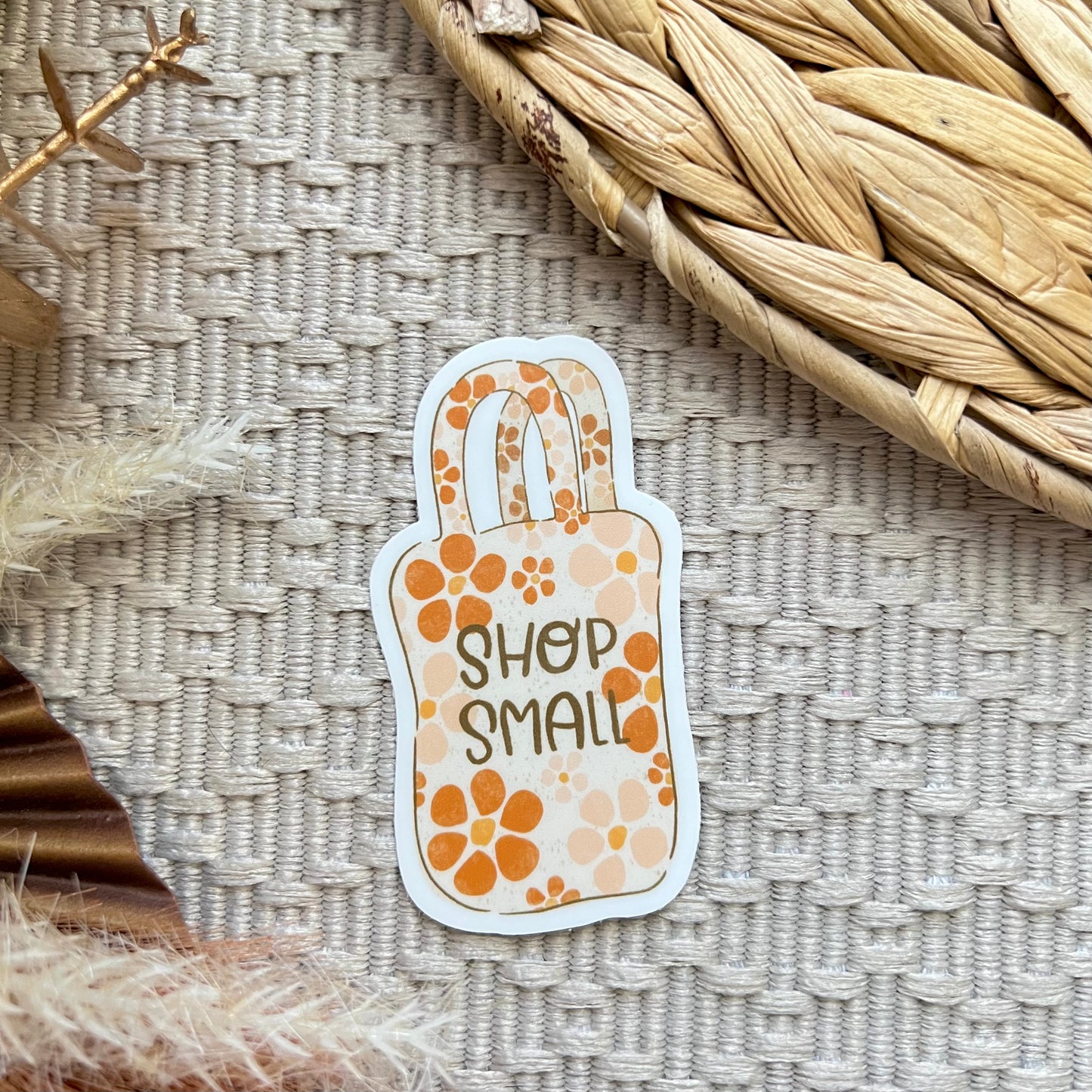 Sticker with 'Shop Small' text on a textured surface