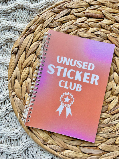 Notebook with 'Unused Sticker Club' on a woven mat