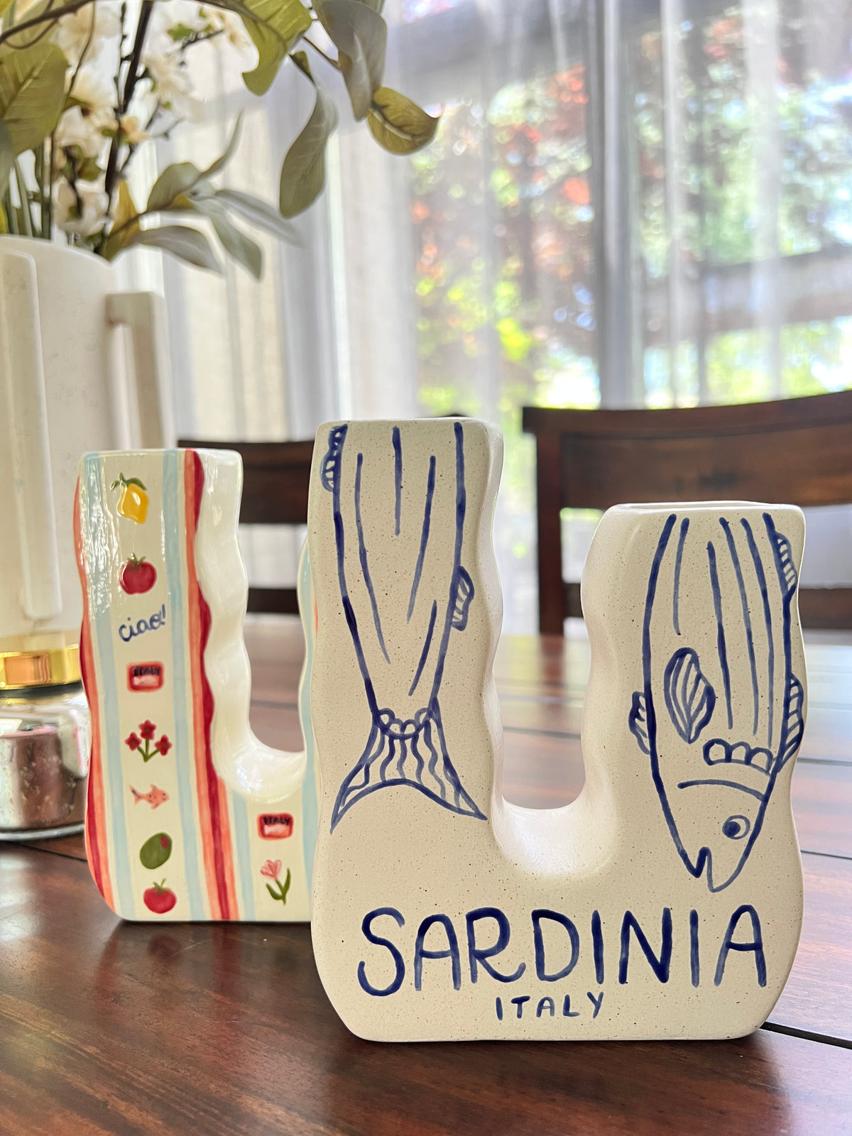Three ceramic vases on a table with 'Sardinia Italy' text