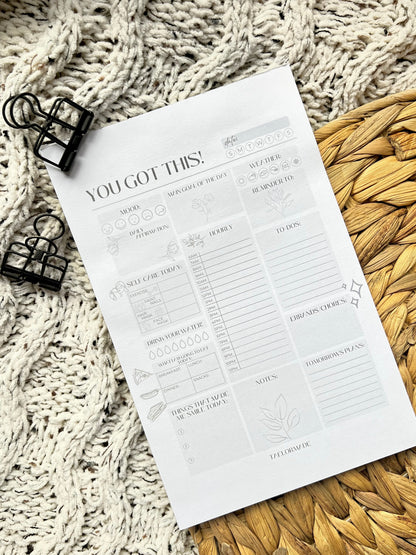 Daily planner notepad with text and icons on a textured surface