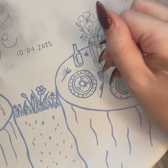 Painters and glazing a design on a ceramic tray