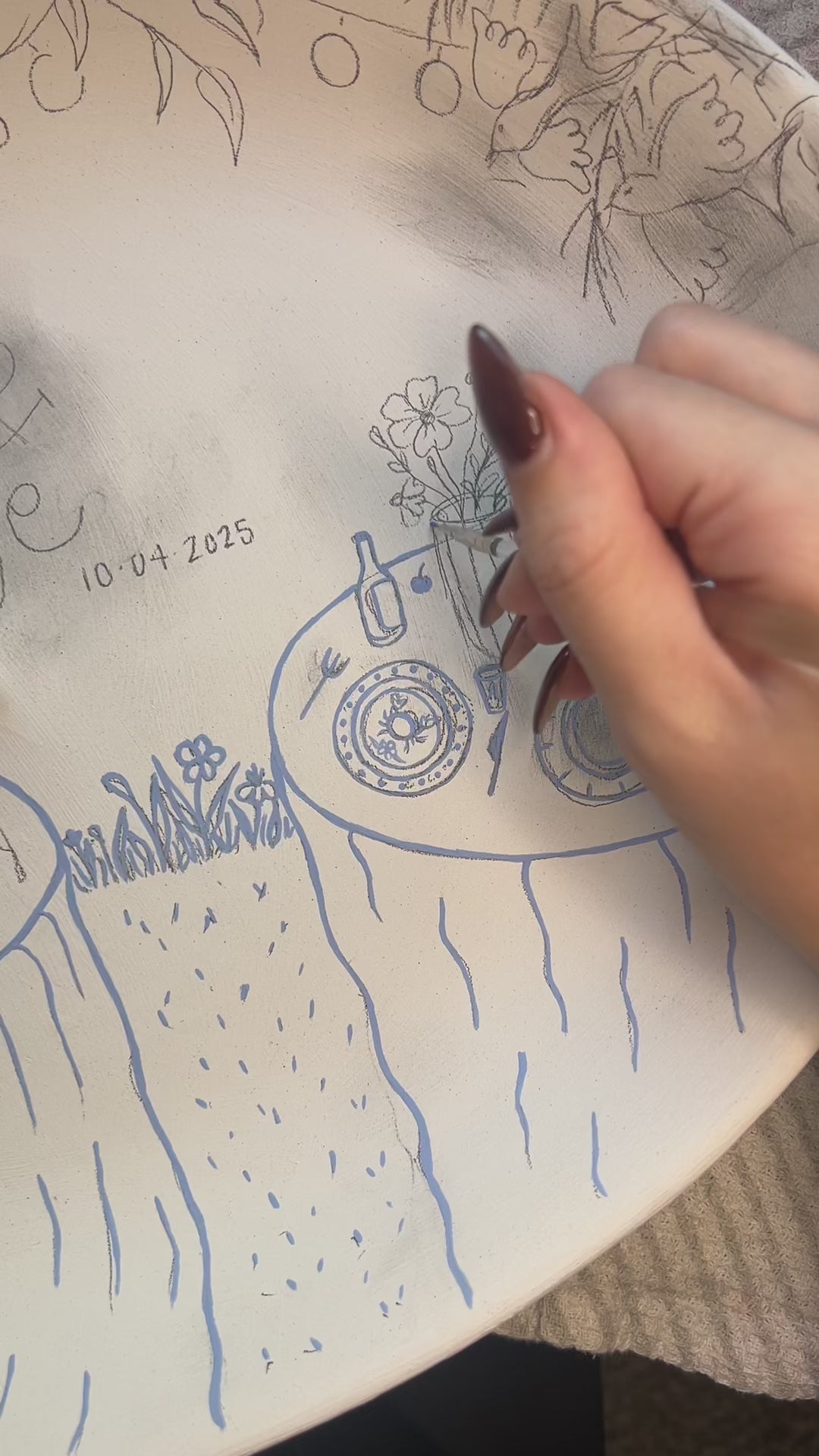 Painters and glazing a design on a ceramic tray